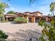 Exterior of a large luxury home with a three-car garage and paved driveway at 11571 E Cochise Dr, Scottsdale, AZ 85259