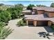 Exterior of a property showing the driveway, garages, and mature landscaping at 11571 E Cochise Dr, Scottsdale, AZ 85259