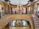 An grand entryway with a large chandelier and open staircase, creating a dramatic and welcoming atmosphere at 11571 E Cochise Dr, Scottsdale, AZ 85259