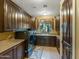 Well-organized laundry room with dark wood cabinets, modern appliances, and a window at 11571 E Cochise Dr, Scottsdale, AZ 85259
