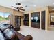 Spacious living room with a large leather sofa, built-in cabinets, and a ceiling fan at 11571 E Cochise Dr, Scottsdale, AZ 85259