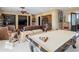 Luxurious living room with a pool table, a large brown leather couch, and elegant decor at 11571 E Cochise Dr, Scottsdale, AZ 85259