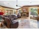 Spacious living room with a fireplace, large windows, and a comfortable leather sofa at 11571 E Cochise Dr, Scottsdale, AZ 85259