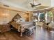 Luxurious main bedroom with ornate bed, large windows, and hardwood floors at 11571 E Cochise Dr, Scottsdale, AZ 85259