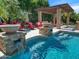 Inviting pool and spa area with a pergola and fire pit at 11571 E Cochise Dr, Scottsdale, AZ 85259