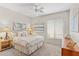 Bright bedroom featuring a ceiling fan, warm lighting, queen bed, and neutral color palette at 12808 W Nogales Dr, Sun City West, AZ 85375