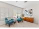 Bright living room with two blue chairs, neutral walls and carpet, plus natural light from window at 12808 W Nogales Dr, Sun City West, AZ 85375