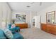 Bright living room with two blue chairs, neutral walls and carpet with hallway and dresser at 12808 W Nogales Dr, Sun City West, AZ 85375