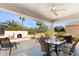 Covered patio featuring an outdoor fireplace, seating, and desert landscaping at 12808 W Nogales Dr, Sun City West, AZ 85375