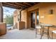 Building entry with a dark wood door and small patio seating at 13450 E Via Linda Dr # 2008, Scottsdale, AZ 85259