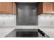 Close-up of a modern glass top cooktop with dark gray backsplash at 13450 E Via Linda Dr # 2008, Scottsdale, AZ 85259