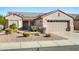 Single-story home with solar panels and a two-car garage at 15174 W Camino Estrella Dr, Surprise, AZ 85374
