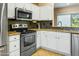 Kitchen boasts stainless steel appliances and dark granite countertops at 15174 W Camino Estrella Dr, Surprise, AZ 85374