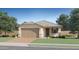 Single-story house with a beige exterior, a two-car garage, and a well-manicured lawn at 15670 W Winslow Ave, Goodyear, AZ 85338