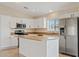 Bright kitchen with stainless steel appliances, a center island, and ample white cabinetry at 16585 W Tonto St, Goodyear, AZ 85338