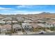 An aerial view of a neighborhood with well-spaced homes and desert landscaping, mountains in the distance at 22501 E Indiana Ave, Queen Creek, AZ 85142