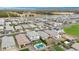 Aerial view of a neighborhood with homes, green lawns, pools, and landscaping; mountains are visible on the horizon at 22501 E Indiana Ave, Queen Creek, AZ 85142