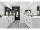 A modern bathroom with dual vanities, black accent wall, and patterned tile flooring at 22501 E Indiana Ave, Queen Creek, AZ 85142