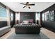 A bedroom featuring a tufted headboard and dark accent wall, and modern chandelier at 22501 E Indiana Ave, Queen Creek, AZ 85142