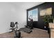 Bedroom featuring home gym equipment against a black accent wall, with plenty of natural light at 22501 E Indiana Ave, Queen Creek, AZ 85142