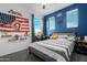 Bright bedroom with striped bedding, baseball decor, and a blue accent wall with a basketball hoop at 22501 E Indiana Ave, Queen Creek, AZ 85142