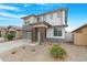 Contemporary two-story home with a gray garage door, stone accents, and manicured landscaping at 22501 E Indiana Ave, Queen Creek, AZ 85142