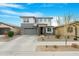 Contemporary two-story home with a gray garage door, stone accents, and manicured landscaping at 22501 E Indiana Ave, Queen Creek, AZ 85142