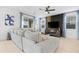 Bright living room with a large sectional sofa, modern decor, a ceiling fan, and ample natural light from the windows at 22501 E Indiana Ave, Queen Creek, AZ 85142