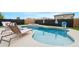 Backyard pool area with a spa, lounge chairs, and a privacy fence at 22501 E Indiana Ave, Queen Creek, AZ 85142