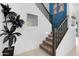Carpeted staircase with dark wood railing leads to the upper level, accented by modern decor at 22501 E Indiana Ave, Queen Creek, AZ 85142