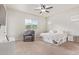 Spacious bedroom with large bed, ceiling fan, and comfortable armchair at 24147 N 165Th Ln, Surprise, AZ 85387