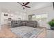 Open living area with grey sectional sofa, ceiling fan, and view to kitchen at 24147 N 165Th Ln, Surprise, AZ 85387