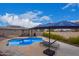 Relaxing pool area with a large umbrella, lounge chairs, and a pergola at 24147 N 165Th Ln, Surprise, AZ 85387