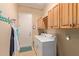 Laundry room with washer, dryer, cabinets, and extra storage at 28175 N 123Rd Ln, Peoria, AZ 85383