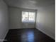 Bright bedroom with dark hardwood floors and window at 3810 N Maryvale Pkwy # 1093, Phoenix, AZ 85031