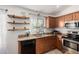 Kitchen with wood cabinets, granite counters, and floating shelves at 3854 W Yellow Peak Dr, San Tan Valley, AZ 85144