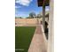 Artificial turf backyard with brick walkway at 42244 W Calle St, Maricopa, AZ 85138