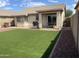 Artificial turf backyard with covered patio, grill, and seating area at 42244 W Calle St, Maricopa, AZ 85138