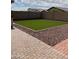 Artificial turf lawn with brick paver border at 42244 W Calle St, Maricopa, AZ 85138