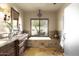 Elegant bathroom with soaking tub, double vanity, and stone tile at 6302 E Monte Cristo Ave, Scottsdale, AZ 85254