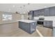 Modern kitchen with gray cabinets, white countertops, and an island at 7607 N 42Nd Ln, Phoenix, AZ 85051