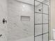Bright shower with marble-look tile and frameless glass enclosure at 7607 N 42Nd Ln, Phoenix, AZ 85051