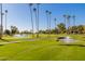 Lush green golf course with water features and palm trees at 9270 W Morrow Dr, Peoria, AZ 85382