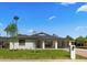 Charming single-story home featuring a manicured lawn, carport, and inviting front porch with a bench at 1036 E Glenn Dr, Phoenix, AZ 85020