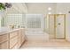 Elegant bathroom with soaking tub, glass shower, and light wood cabinets at 11003 E Turnberry Rd, Scottsdale, AZ 85255