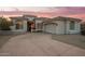 Desert home with a three-car garage, nicely landscaped, and a gorgeous sunset at 11003 E Turnberry Rd, Scottsdale, AZ 85255