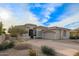 Beautiful desert landscape surrounds this single-story home with a three-car garage at 11003 E Turnberry Rd, Scottsdale, AZ 85255