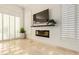 Living area with a fireplace, large windows, and plantation shutters at 11003 E Turnberry Rd, Scottsdale, AZ 85255