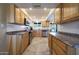 Spacious kitchen featuring wood cabinetry, stainless steel appliances, tile backsplash, and ample counter space at 13530 W Spanish Garden Dr, Sun City West, AZ 85375