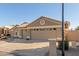 Tan two-story house with a three-car garage and desert landscaping at 15491 W Amelia Dr, Goodyear, AZ 85395